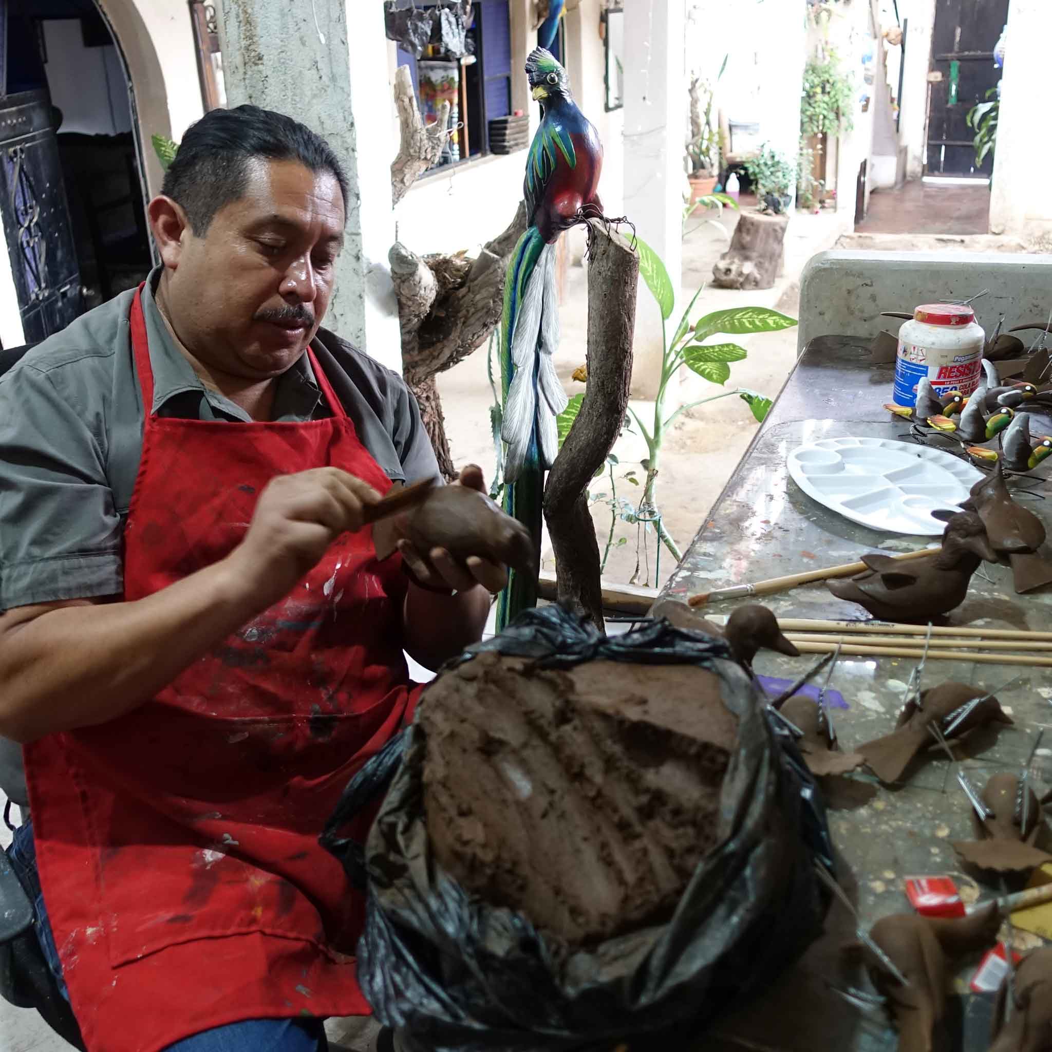 Guatemalan artisan making ceramic figurines in his workshop
