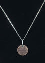 Delicate figaro style sterling silver chain with a penny pendant