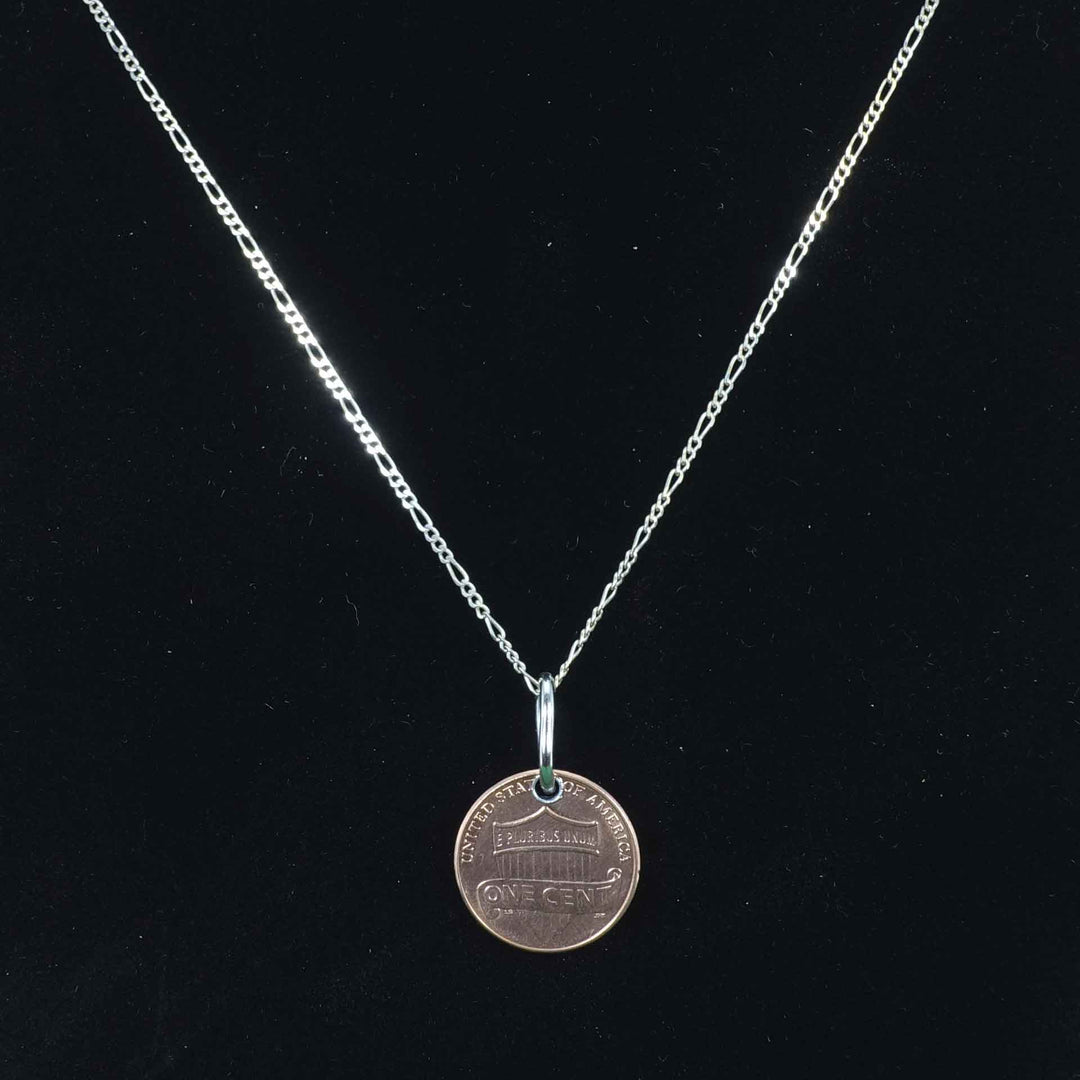 Delicate figaro style sterling silver chain with a penny pendant