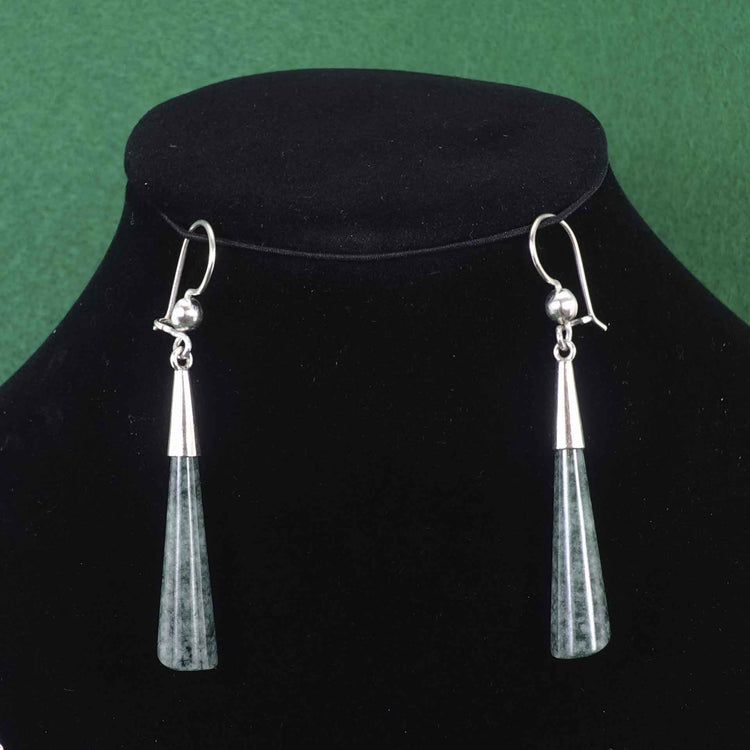 Dark green jade and silver teardrop shaped earrings on a black background