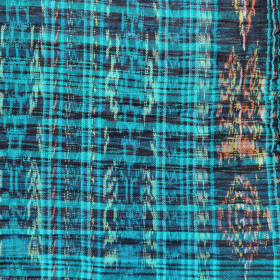 Close-up of a fabric with a plaid pattern in blue, black, and orange.
