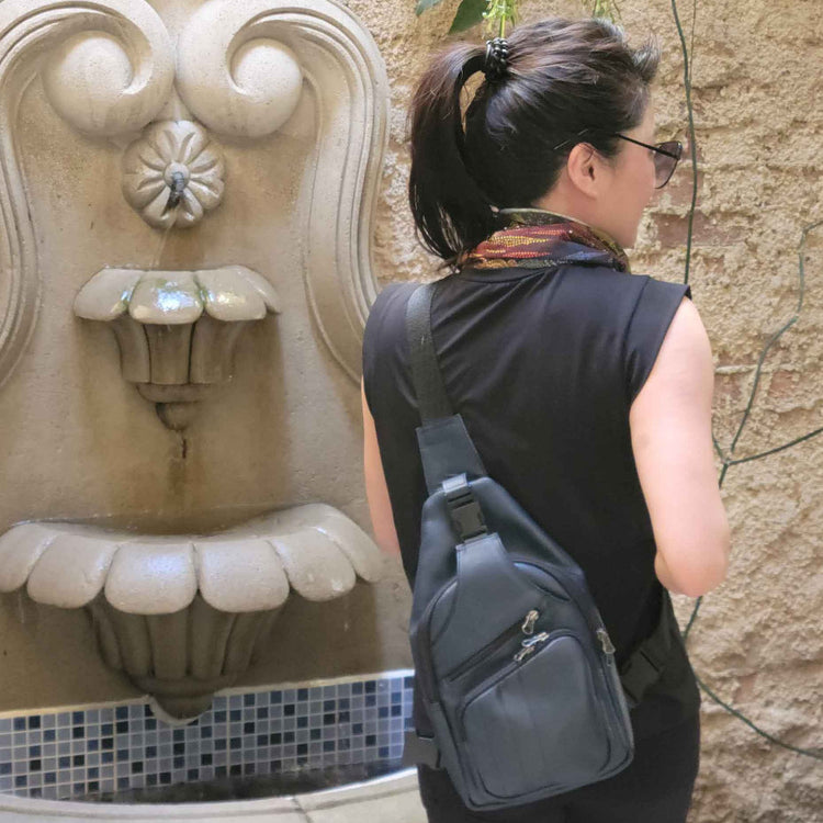 Woman in Guatemala, carrying a leather sling bag in indigo blue