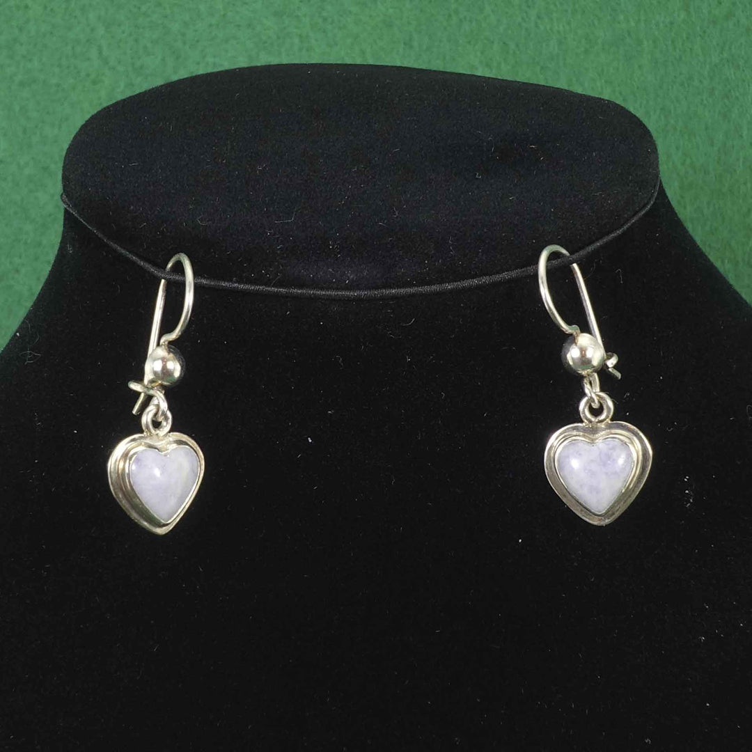 Heart shaped earrings in a silver setting with moon colored jade hearts